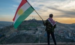 Teenager holding the Kurdistan flag in northern Iraq at sunset time on Nowruz 2019