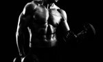 Black and white studio shot of a ripped shirtless athlete exercising with weights in both hands gym lifestyle bodybuilding strengthening power weightlifting health sport sporty masculine motivation