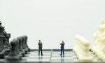 Miniature people businessmen standing on a chessboard with a chess piece on the back Negotiating in business. as background business concept and strategy concept with copy space.